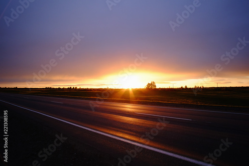 Nature landscape of a sunset light above asphalt road.