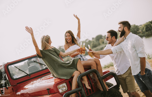 Young people drinking and having fun by car © BGStock72