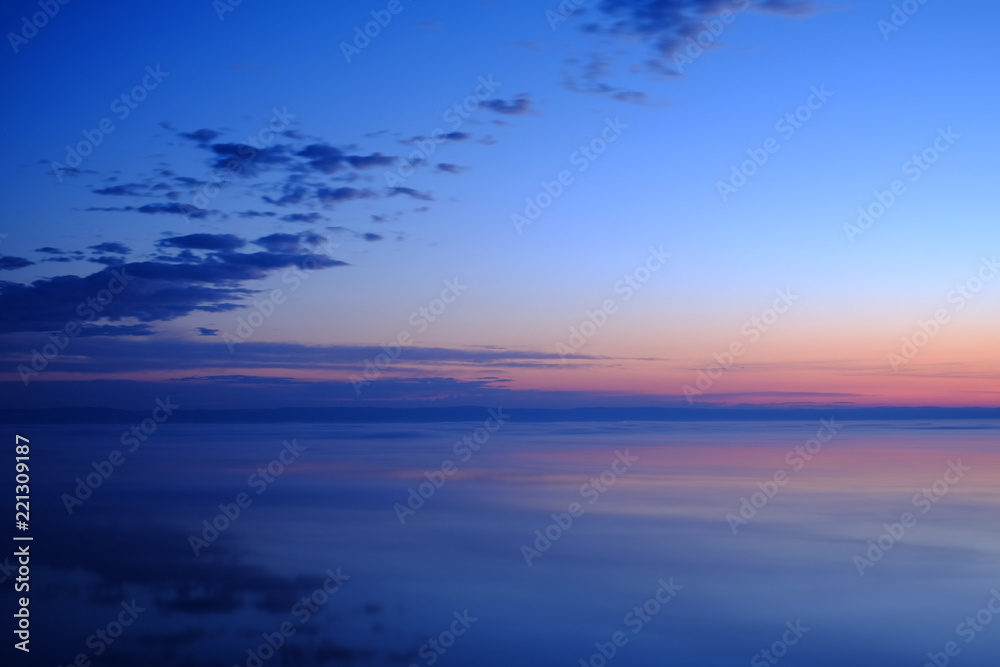 Beautiful sunset over sea with reflection in water.