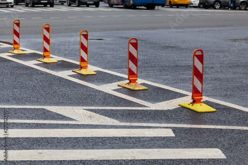 Traffic cones on asphalt road with white marking and cars © Aleksey Sidorov