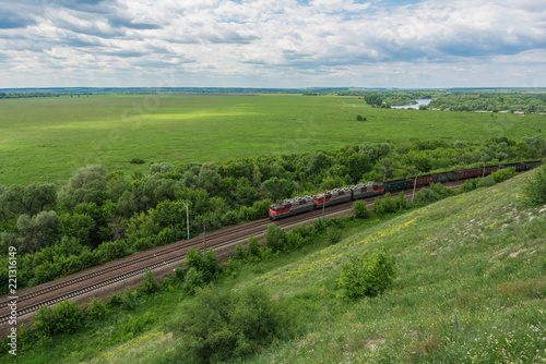 Freight train with locomotives passing by rail in Russia, along the typical Russian landscape, top view