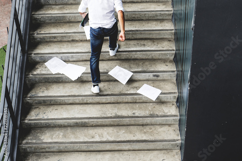 businessman hurrying time with papers document on ground