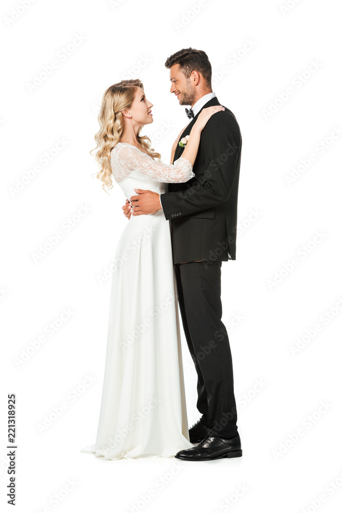 side view of young bride and groom embracing isolated on white
