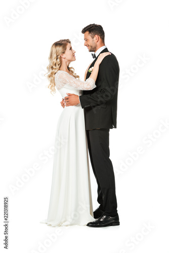 side view of young bride and groom embracing isolated on white