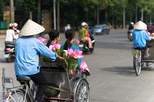 Cyclo (pedicab) driver wears conical hat on Hanoi street