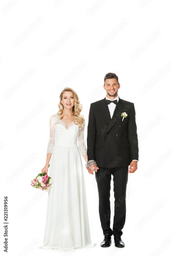 happy young bride and groom holding hands and looking at camera isolated on white happy young bride and groom holding hands and looking at camera isolated on white