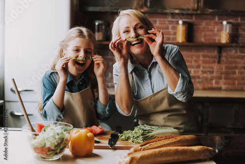 Grandma and Granddaughter Having Fun in Kitchen