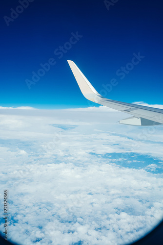 airplane wing with blue sky and cloud