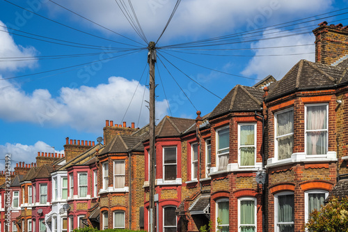 A row of typical British terraced houses in London with overhead cable lines photo