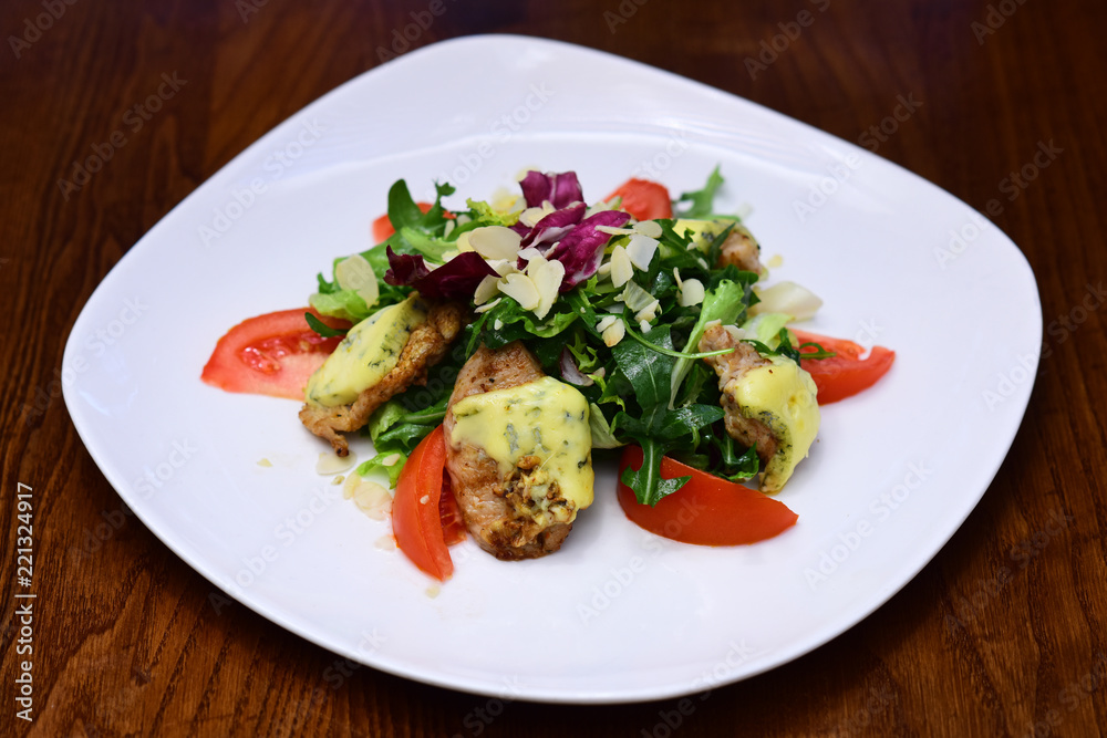 Salad with chicken breast meat and cheese. Mixed salad dish with fresh tomato and leaves of arugula and lettuce on plate. The pleasure of variety on your plate Salad with chicken breast meat and cheese. Mixed salad dish with fresh tomato and leaves of arugula and lettuce on plate. The pleasure of variety on your plate