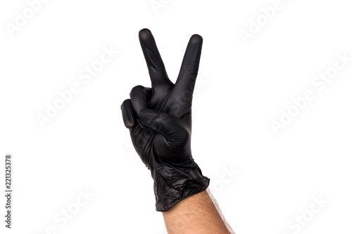 Isolate a man's hand showing two fingers in a black rubber glove on a white background. The gesture of victory. The concept of successful work of a chef of a surgeon or cleaning