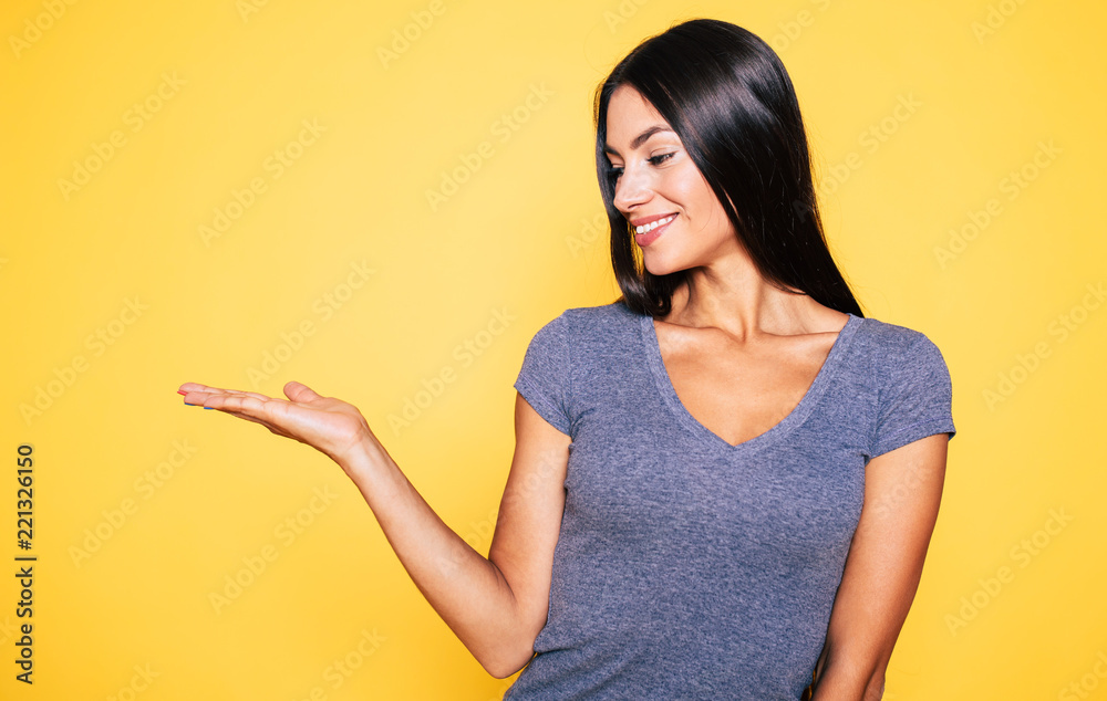 Photo of young excited beautiful happy brunette woman, girl pointing away and smile isolated on yellow background banner Photo of young excited beautiful happy brunette woman, girl pointing away and smile isolated on yellow background banner