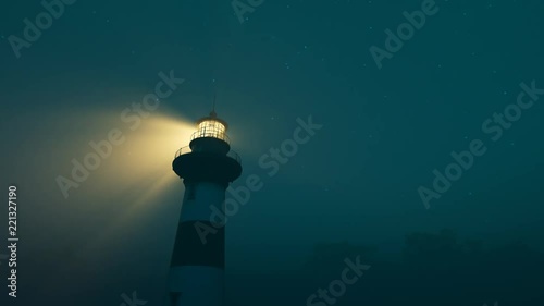 Lighthouse light spinning around. Tall tower standing on the coastline.