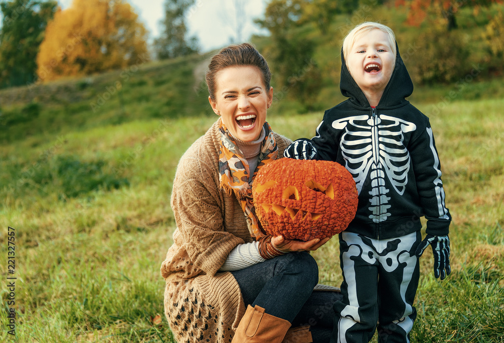 Fototapeta premium mother and child showing Halloween pumpkin Jack O’Lantern