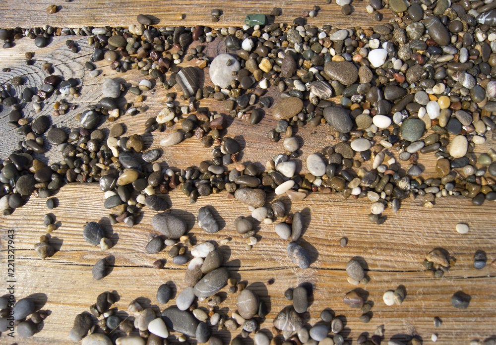 Fototapeta premium Wet colored stones lie on the beach