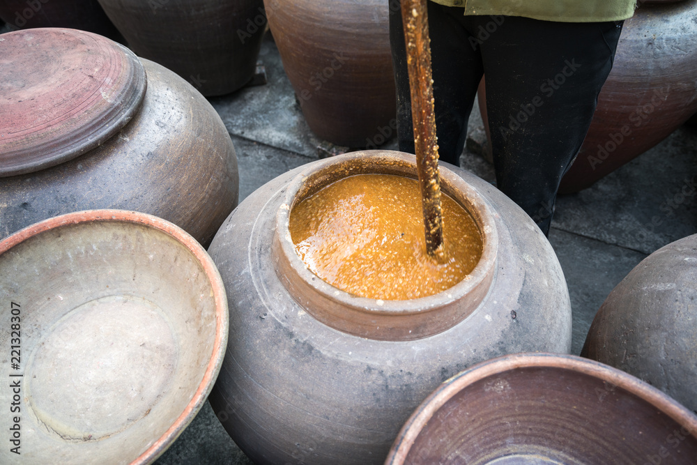 Jars of processing soybean jam made by traditional outdoor way under natural sunlight