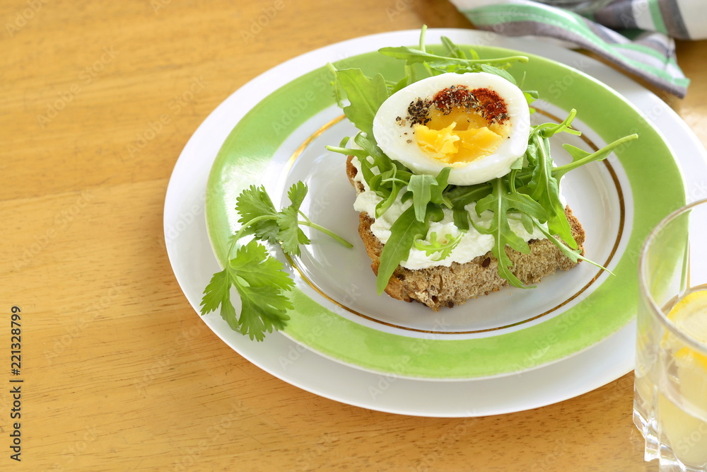 Toast with cream cheese, arugula and boiled egg, healthy breakfast, copy space Toast with cream cheese, arugula and boiled egg, healthy breakfast, copy space