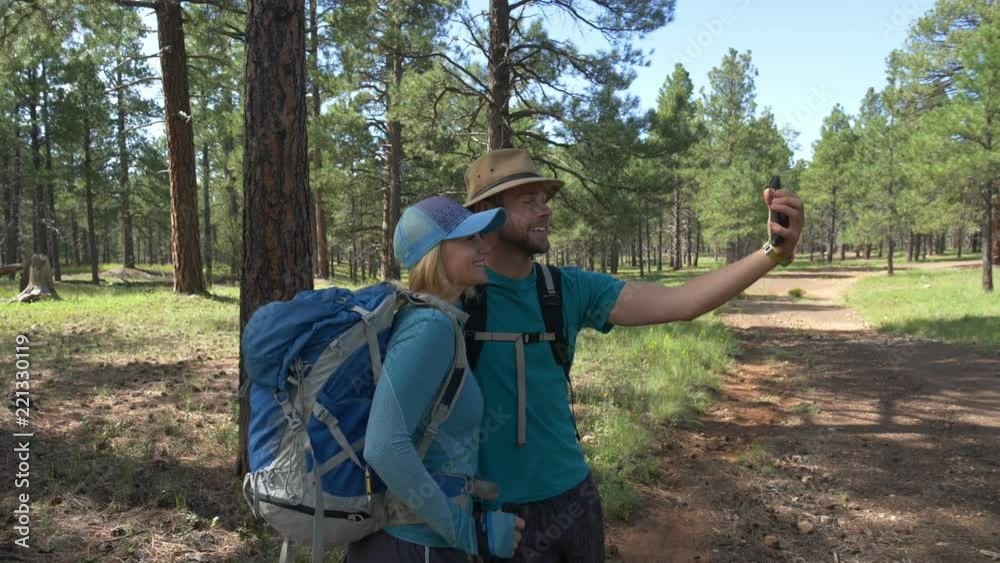 An attractive young couple taking a selfie photo while hiking An attractive young couple taking a selfie photo while hiking