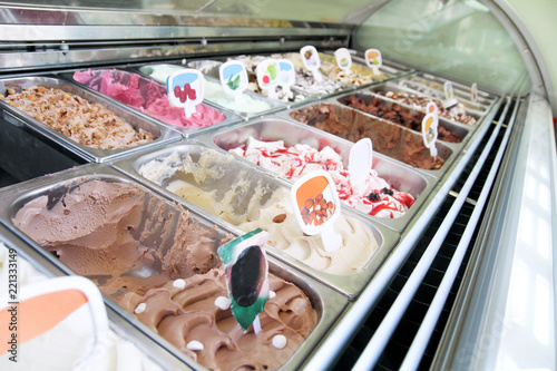 Ice cream fridge with creamy and fruit Italian ice cream steel serving counter with many of refreshing sweet scoopable flavors. Ice cream display, various flavors of gelato ice cream. Pastry shop. © zoranlino