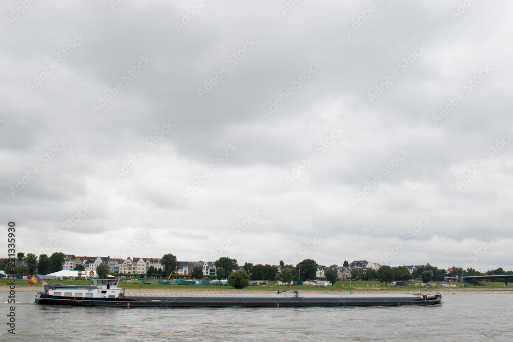 ein transport schiff mit container beladen auf dem rhein in düsseldorf deutschland fotografiert während einer sightseeing boottour auf dem rhein in düsseldorf deutschland mit weitwinkelobjektiv