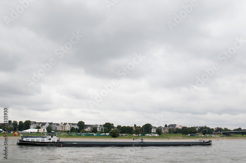 ein transport schiff mit container beladen auf dem rhein in düsseldorf deutschland fotografiert während einer sightseeing boottour auf dem rhein in düsseldorf deutschland mit weitwinkelobjektiv