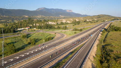 Cycling competition on a road between green mountains