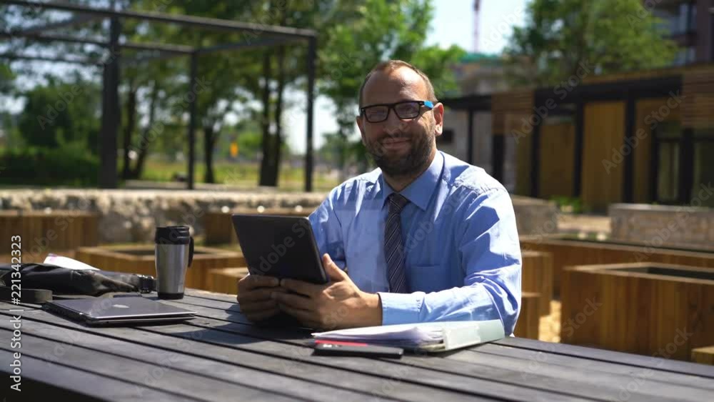 Portrait of happy businessman with tablet computer sitting in city park
Portrait of happy businessman with tablet computer sitting in city park