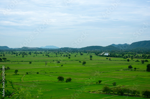 landscape with green field, mountains and blue sky