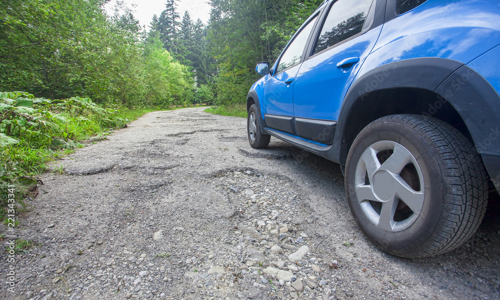 car wheel and cracked damaged road in the forest car wheel and cracked damaged road in the forest
