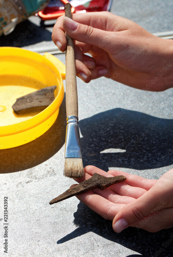 Archaeologist clears brush iron tip medieval arrowhead