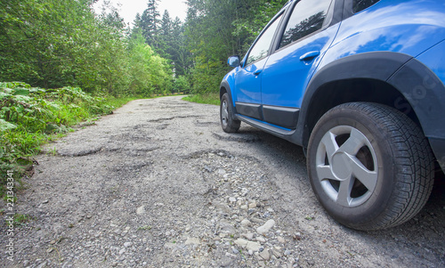 car wheel and cracked damaged road in the forest