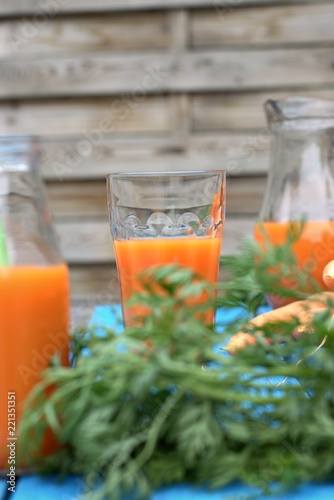 Healthy eating,tasty and vegetable concept-natural homemade carrot juice in glass on an old wooden blue table in the background.