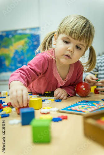 Caucasian little girl playin with Montessori wooden toys