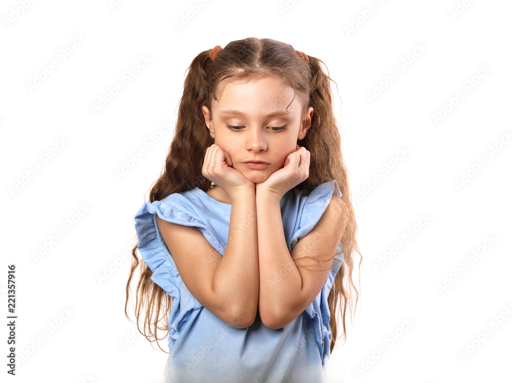 Beautiful girl with sad eyes looking down with hands under the face. Closeup portarit of cute kid with long hair isolated on white background Beautiful girl with sad eyes looking down with hands under the face. Closeup portarit of cute kid with long hair isolated on white background