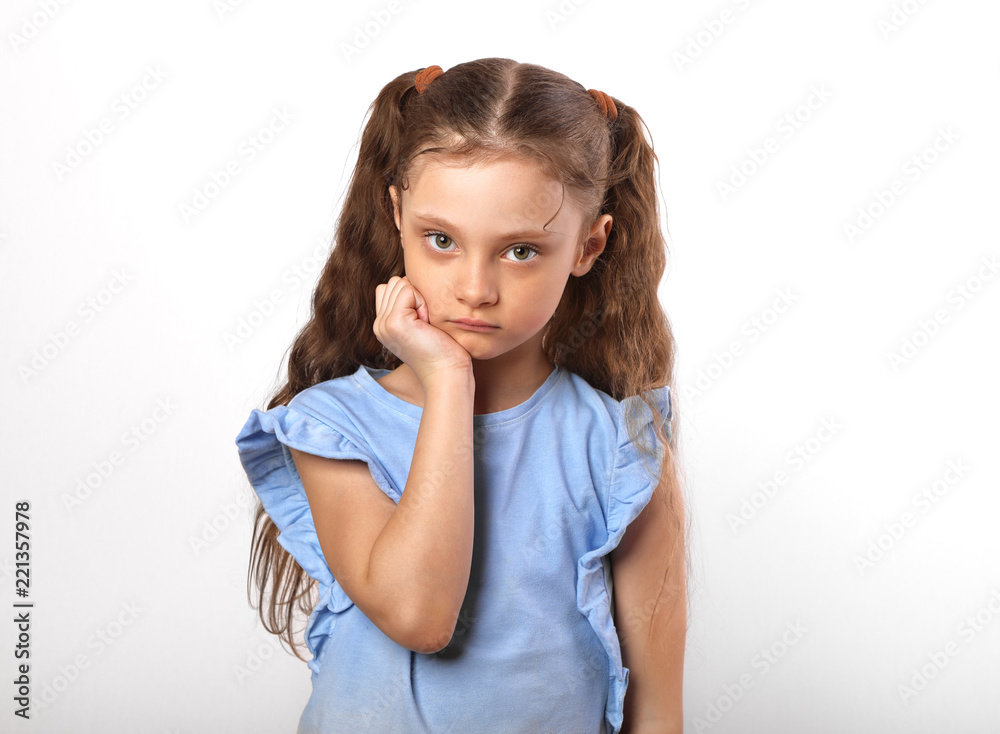 Beautiful girl looking sad with pouted lips. Closeup portarit of cute kid with long hair on white background Beautiful girl looking sad with pouted lips. Closeup portarit of cute kid with long hair on white background