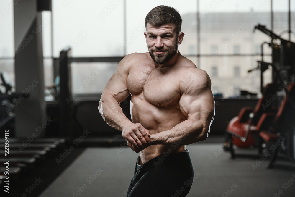 Brutal strong bodybuilder athletic men pumping up muscles with dumbbells Brutal strong bodybuilder athletic men pumping up muscles with dumbbells