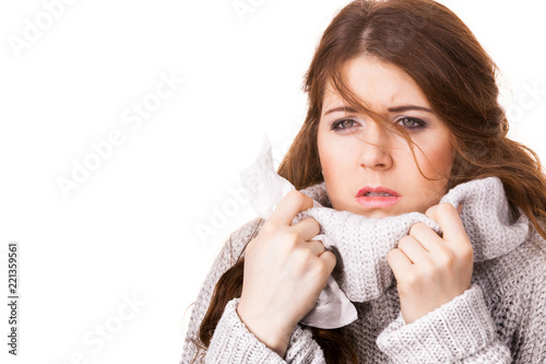 Sick freezing woman sneezing in tissue