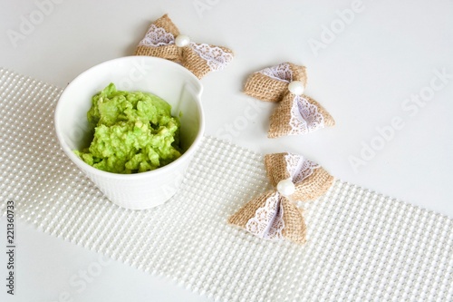 Tasty green avocado coconut sauce in the white bowl. photo