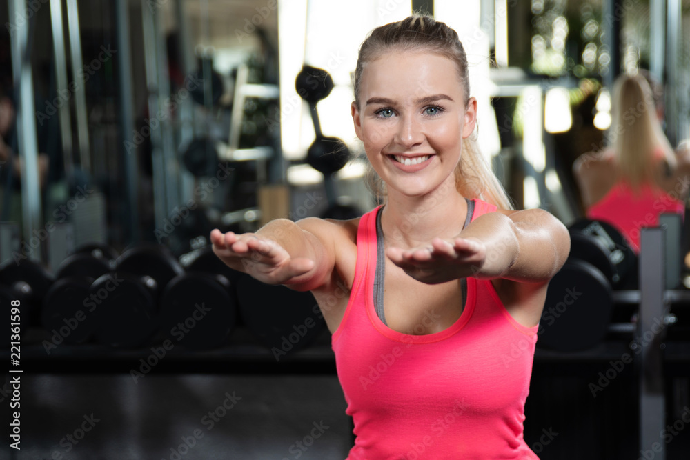 Fototapeta premium Frau macht Kniebeugen im Fitnessstudio 