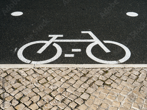 From above shot of white marking of bicycle sign on asphalt pavement on street