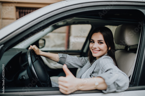 Young Woman sitting in the car and showing thumbs up © F8  \ Suport Ukraine