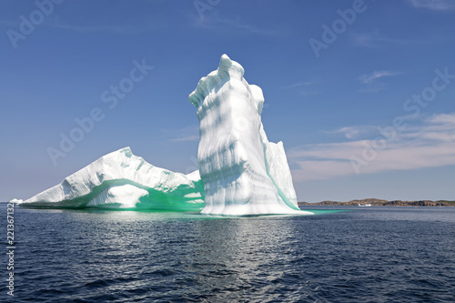 Iceberg in front of a rocky island, Newfoundland and Labrador, Canada