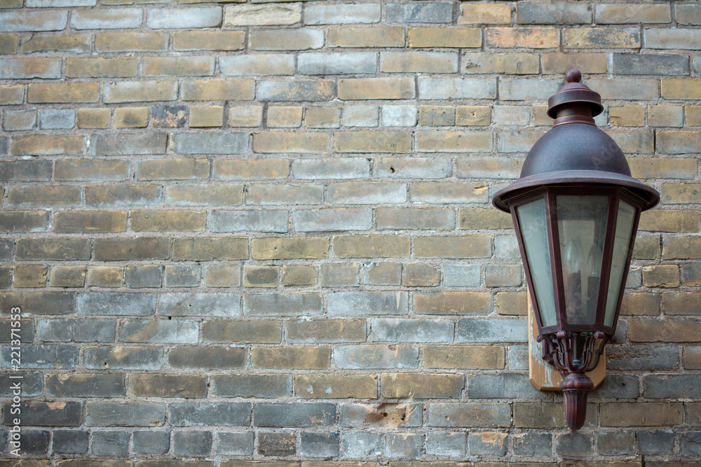 Carriage lamp fixture against rustic brick background
