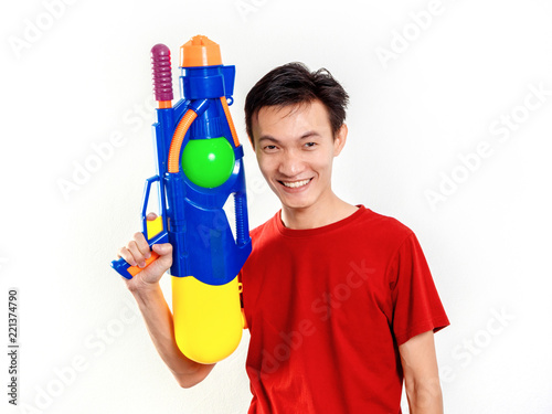 Young man with water gun toy Thailand Songkran Festival. Asian one person wear red short sleeves. isolated.