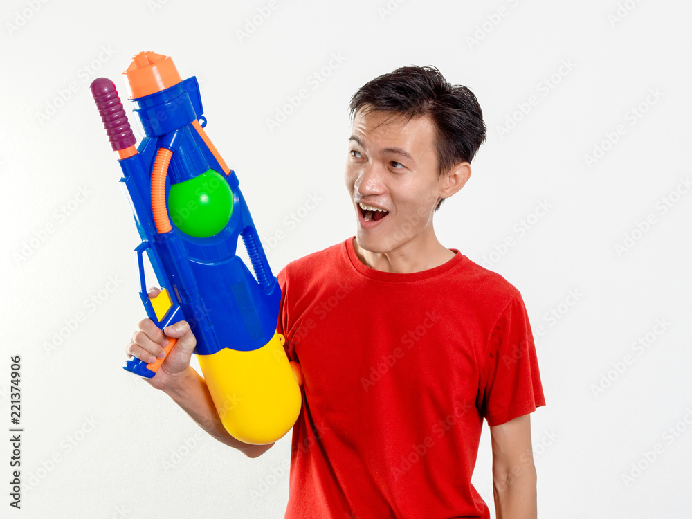 Young man with water gun toy Thailand Songkran Festival. Asian one person wear red short sleeves. isolated. Young man with water gun toy Thailand Songkran Festival. Asian one person wear red short sleeves. isolated.