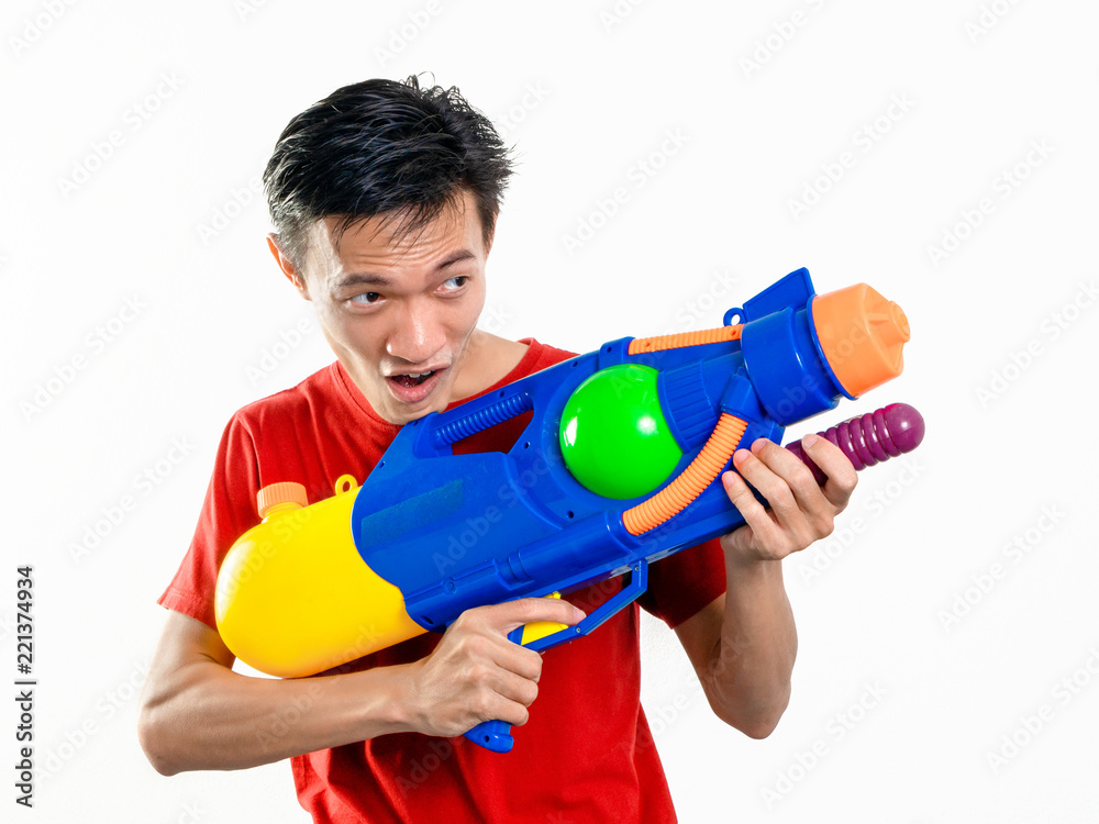 Young man with water gun toy Thailand Songkran Festival. Asian one person wear red short sleeves. isolated. Young man with water gun toy Thailand Songkran Festival. Asian one person wear red short sleeves. isolated.