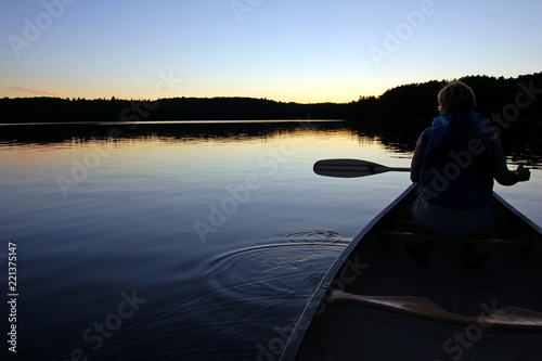 Sunset and canoe trip in calm lake in Algonquin Park