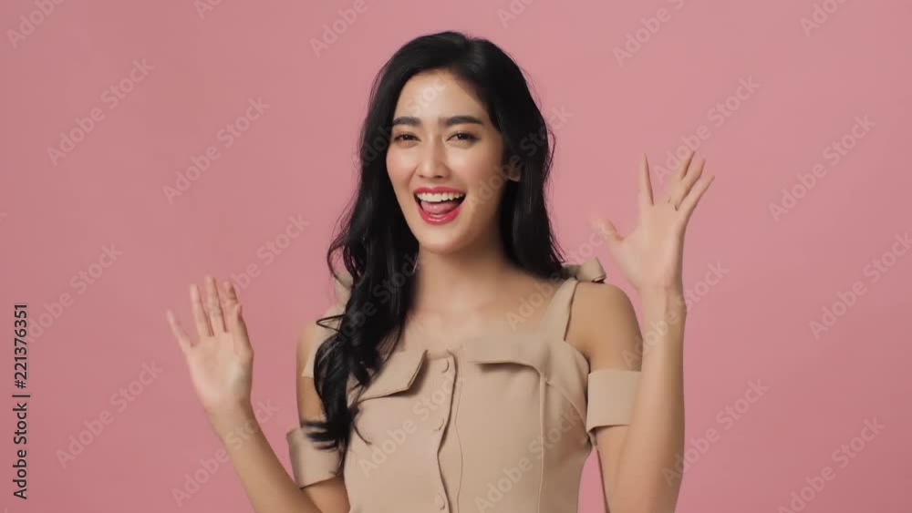 Attractive asian woman having fun smiling and dancing in studio. Portrait of female posing at camera on pink background with copy space. Attractive asian woman having fun smiling and dancing in studio. Portrait of female posing at camera on pink background with copy space.