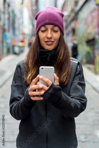 Young woman smiling and taking a selfie with her smartphone