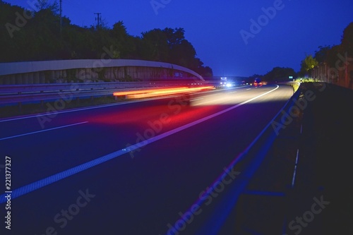Evening shot of trucks doing transportation and logistics on a highway. Highway traffic - motion blurred truck on a highway motorway speedway at dusk